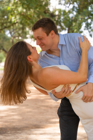 Robert and Dominique's engagement at Hermann Park, featuring a romantic dip as they share a joyful kiss